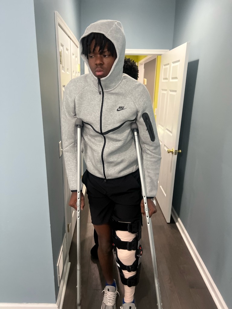 BJ Garrett on crutches after surgery, walking with a knee brace