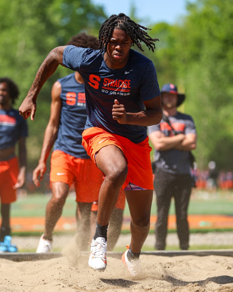 BJ Garrett sprinting through a sand pit during Syracuse training