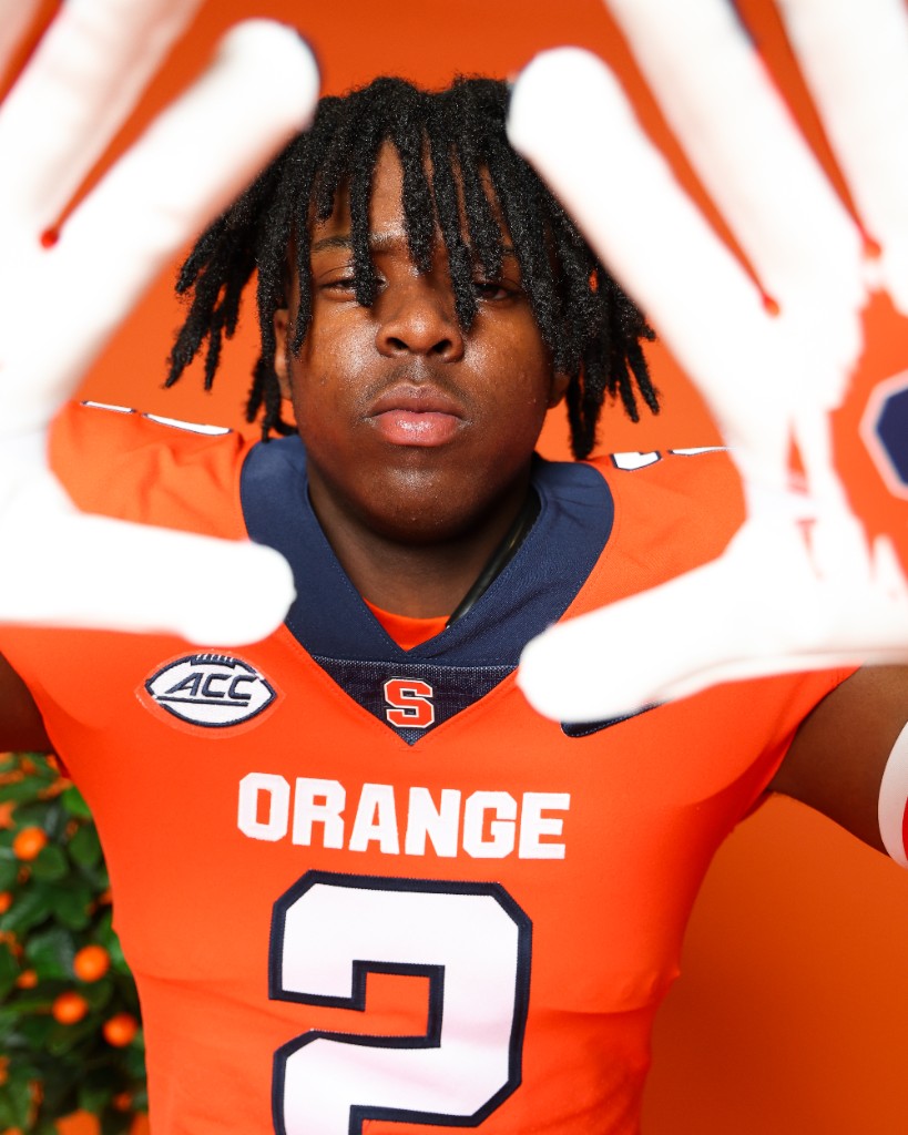 BJ Garrett in an orange Syracuse jersey framing his face with gloved hands